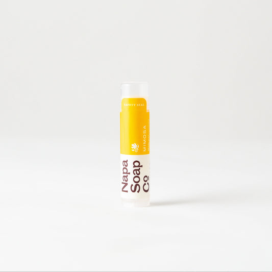 Mimosa Lip Balm by Napa Soap Company, yellow and white, on a white background