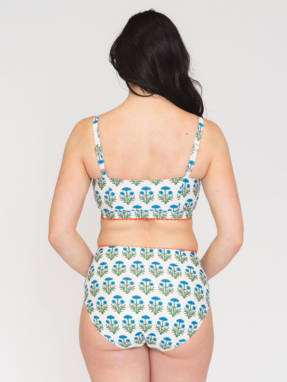 Woman wearing a floral bikini set on a plain background