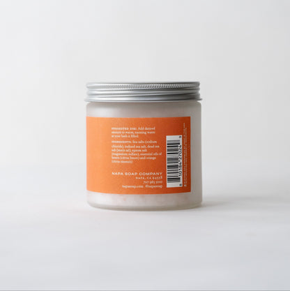 Mandarin Chardonnay bath salt soak jar with an orange label and silver lid on a white background