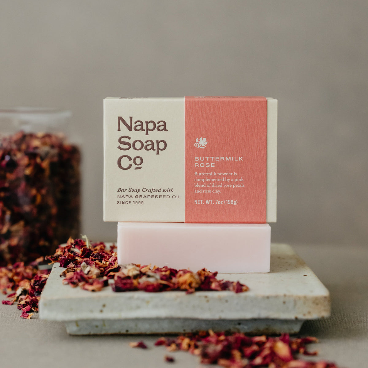 Napa Soap Co bar soap with packaging on a stone surface with dried flowers.