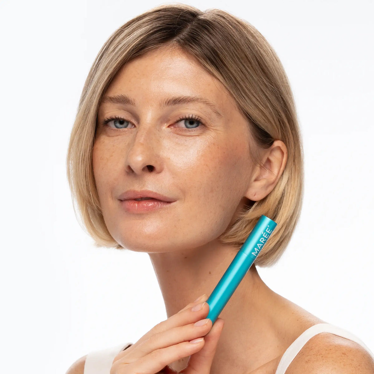 Woman holding a blue pen with a visible brand name against a white background