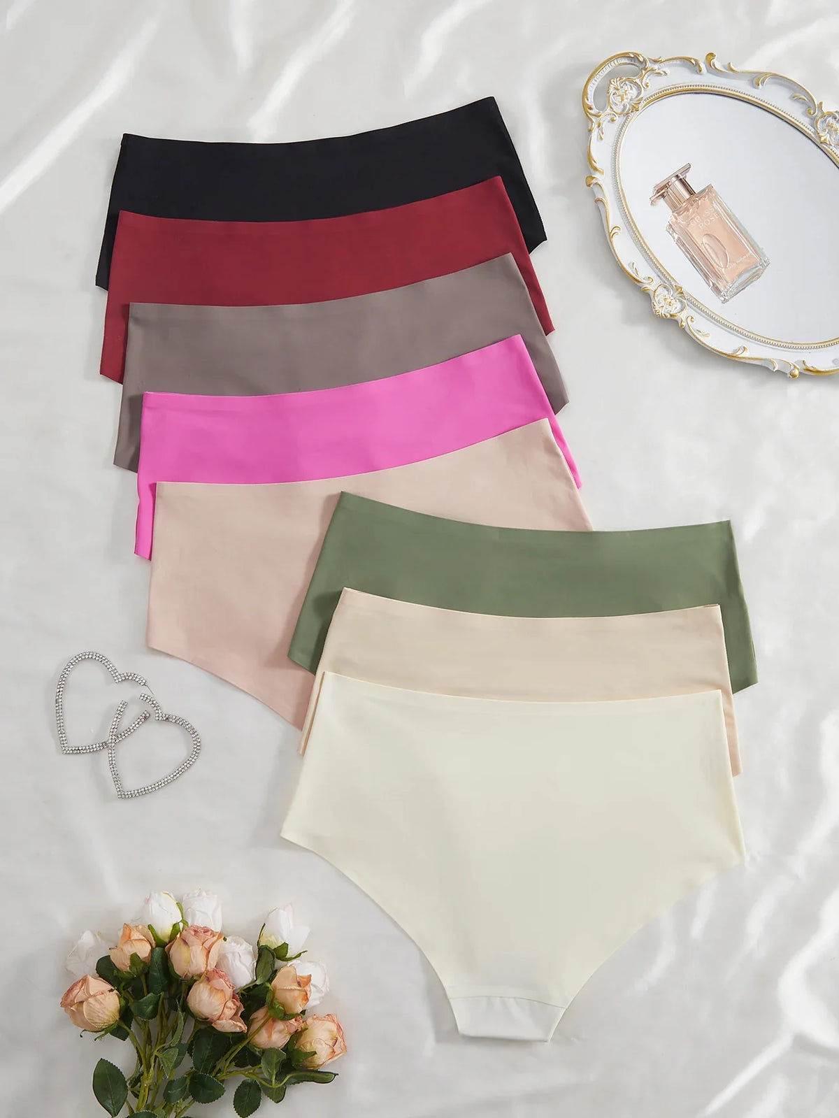 Set of colorful women's underwear on a light background with decorative elements.