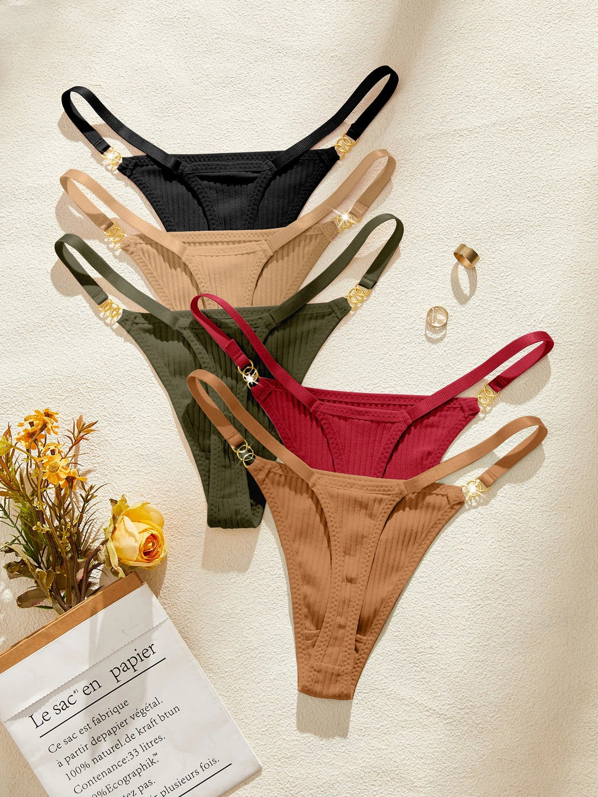 Four pairs of women's underwear in black, beige, green, and red on a light background.