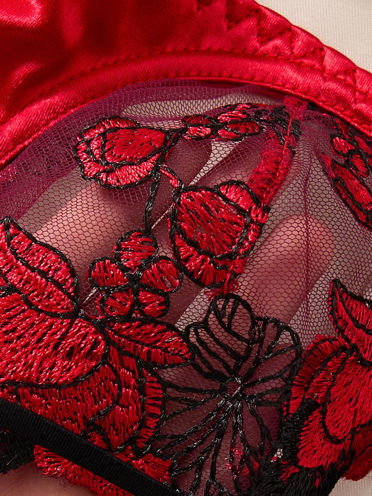 Close-up of red lace lingerie with floral embroidery