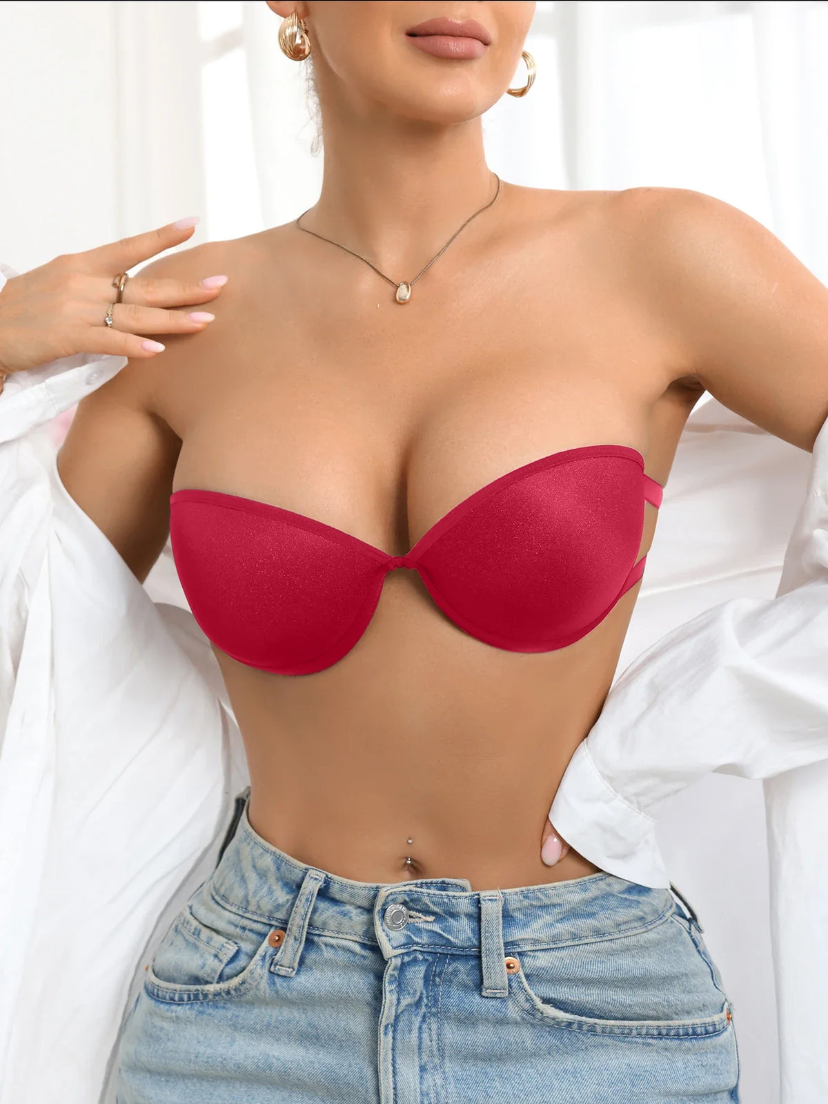 Person wearing a red strapless top and blue jeans against a white background