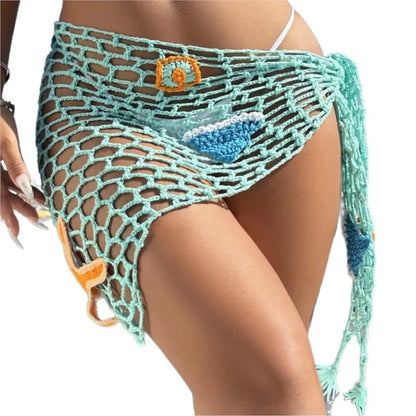 Teal crochet skirt with decorative elements on a white background