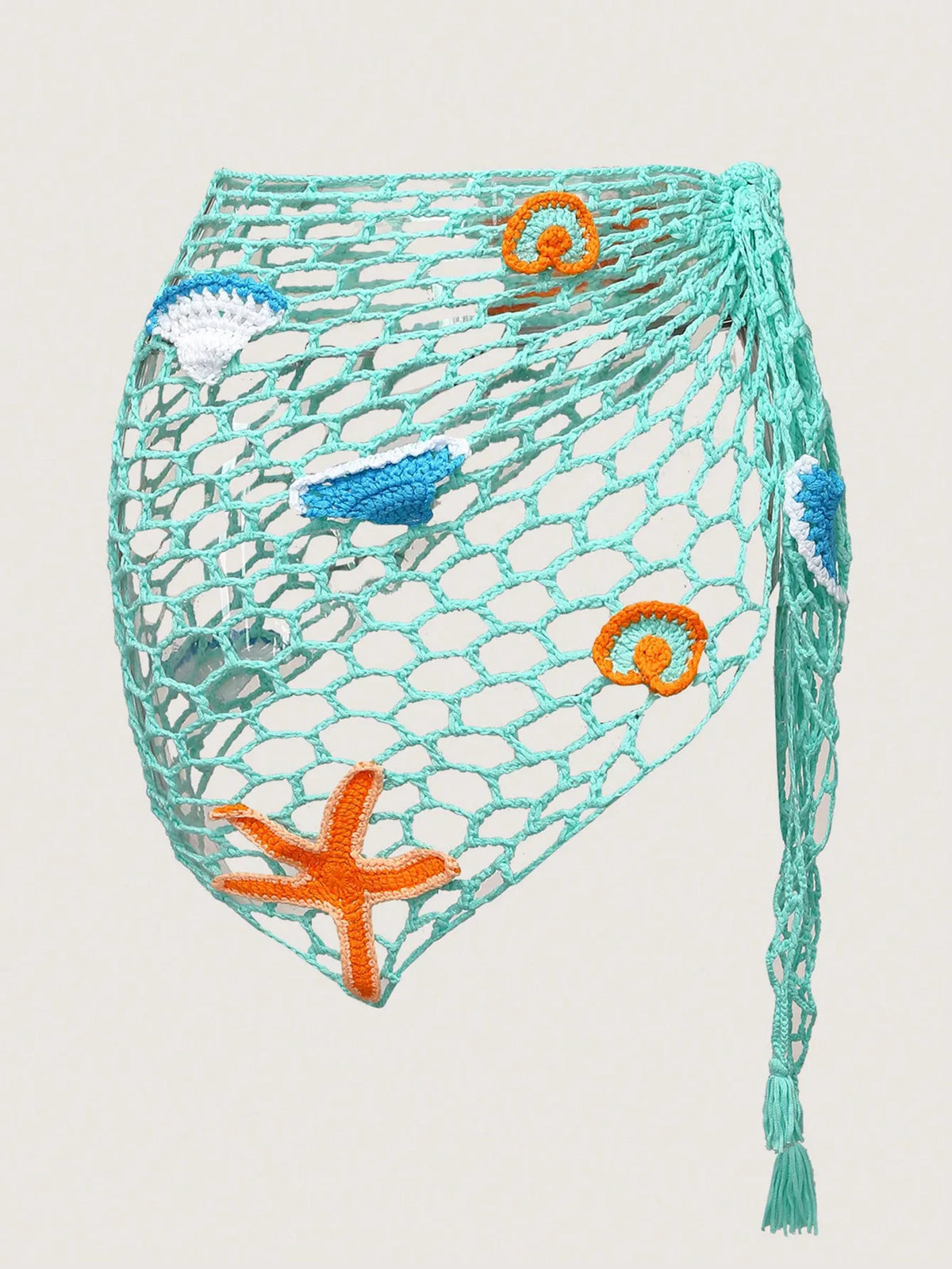 Crocheted net bag with sea-themed decorations on a light gray background