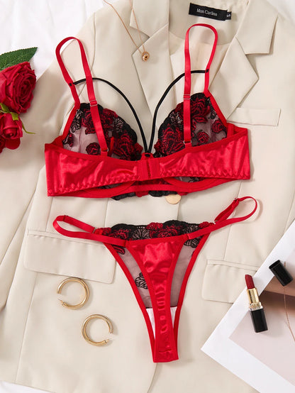 Red lingerie set with black lace details on a beige blazer with accessories.