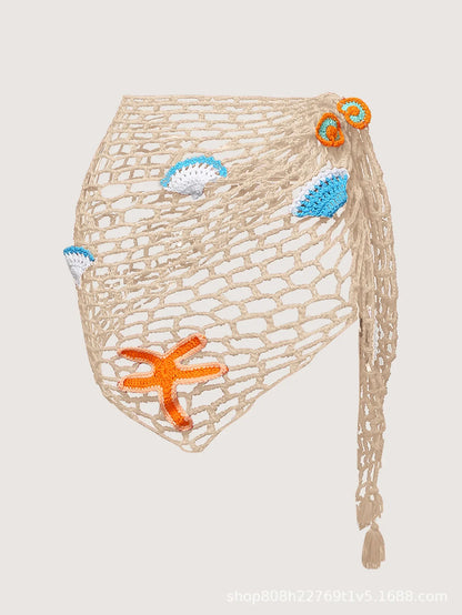 Beige crochet bag with starfish and shell decorations on a light gray background