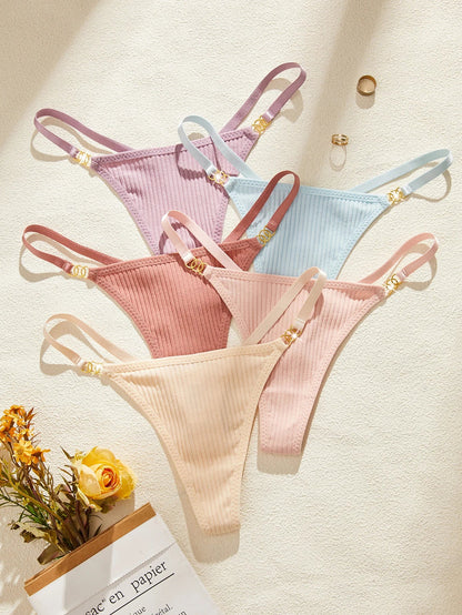 Set of three ribbed thongs in pink, blue, and beige on a light background.