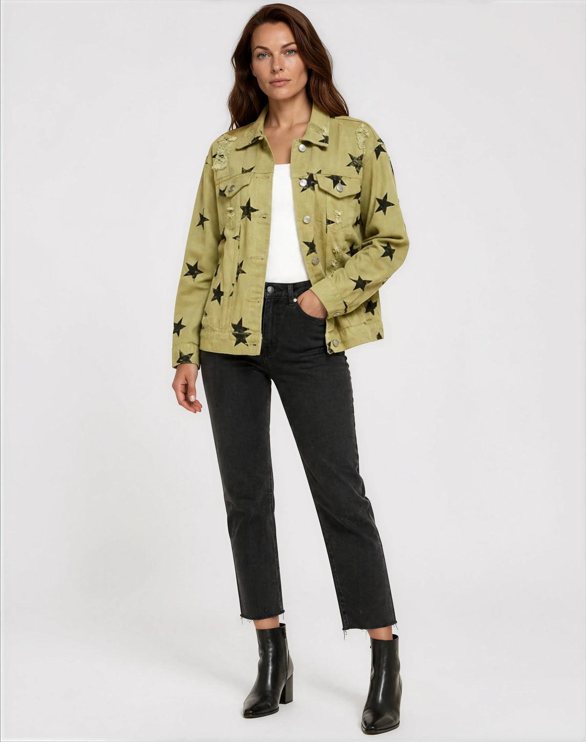 Woman wearing a green jacket with star patterns, white top, black pants, and black boots on a white background