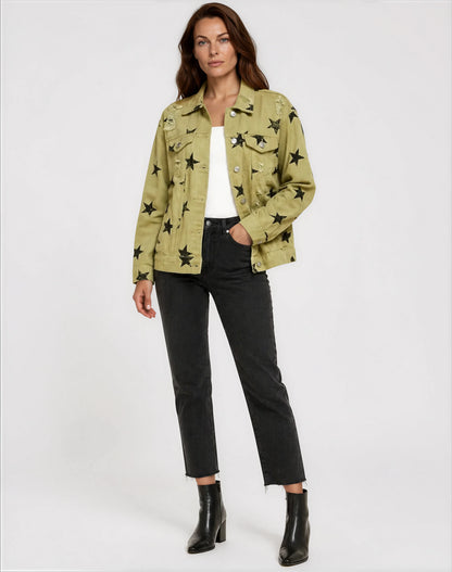 Woman wearing a green jacket with star patterns, white top, black pants, and black boots on a white background