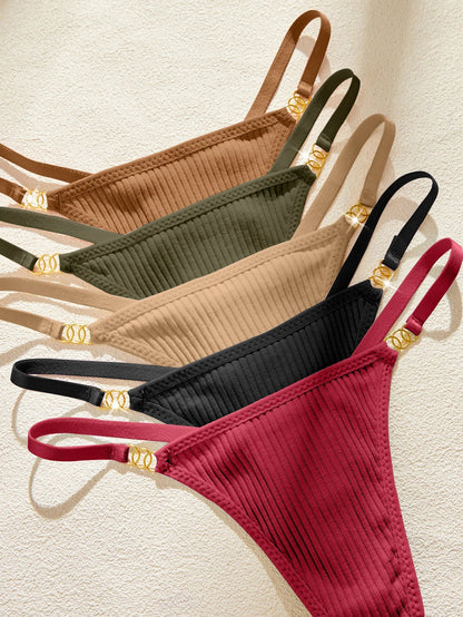 Set of five ribbed thongs in different colors on a textured beige background
