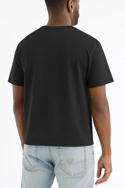 Person wearing a black t-shirt and light blue jeans on a white background