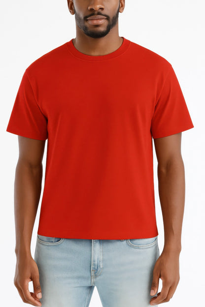 Man wearing a red t-shirt and light blue jeans on a white background