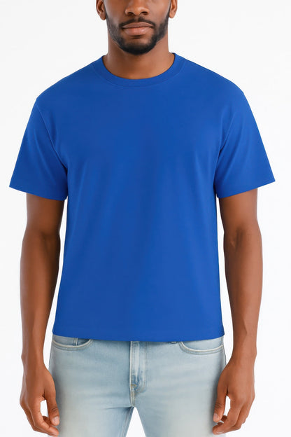 A man wearing a solid royal blue short-sleeve crewneck t-shirt and light wash jeans, shown from the chin down against a plain white background.