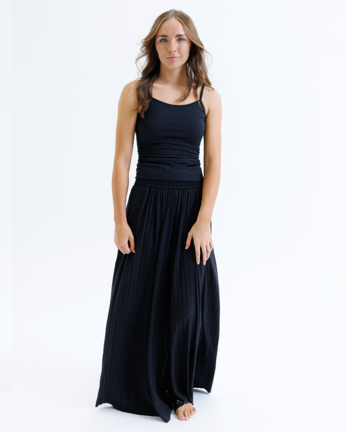 Woman wearing a black sleeveless dress on a white background
