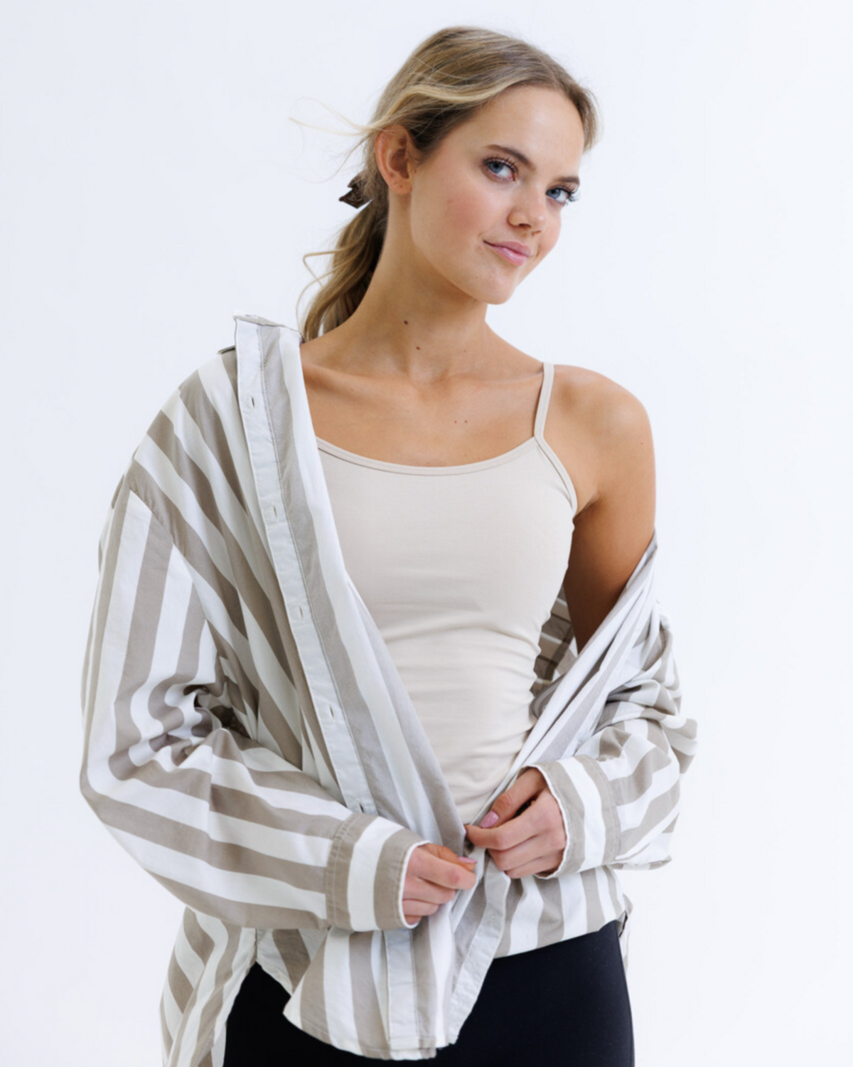 Woman wearing a striped cardigan over a white top on a white background