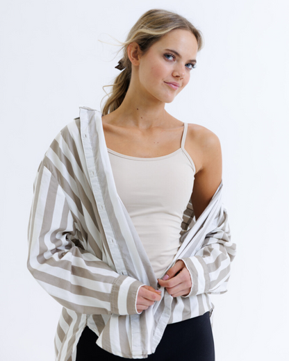 Woman wearing a striped cardigan over a white top on a white background