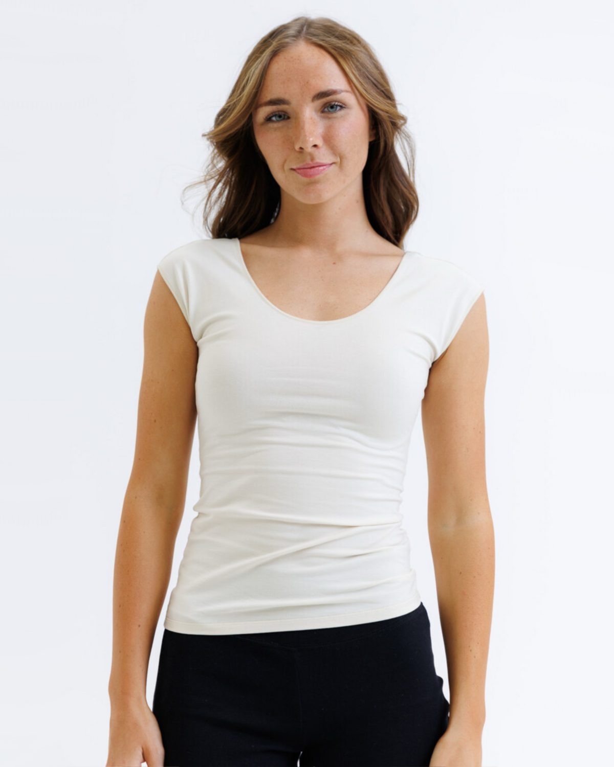 Woman wearing a white t-shirt against a plain background