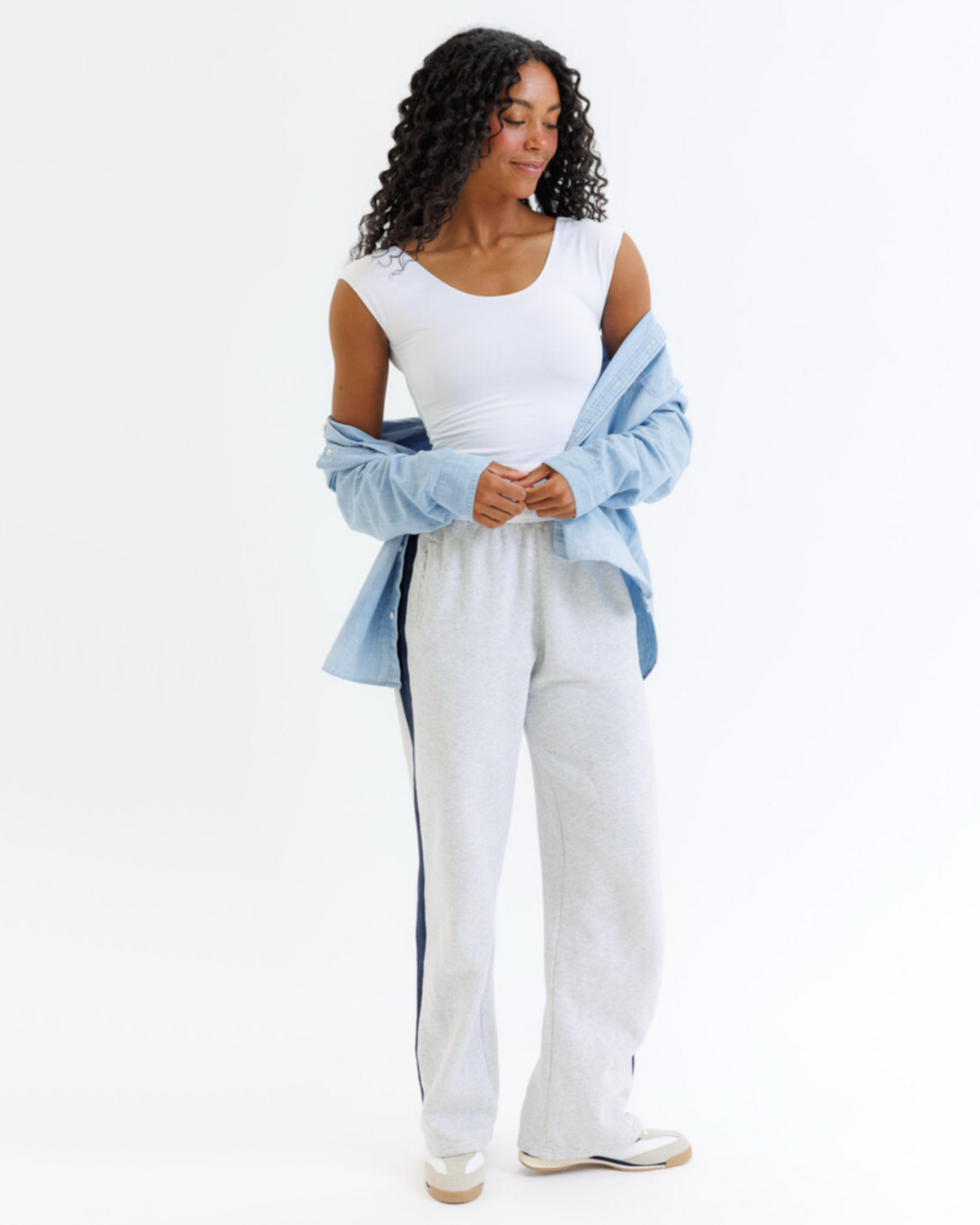 Woman wearing a white outfit with a blue shawl on a white background