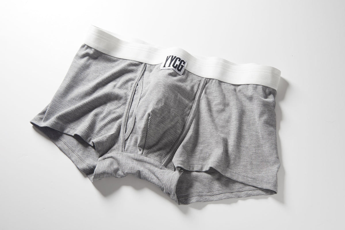 Gray textured boxer briefs with a white elastic waistband and a black logo reading 'YCCB' on the front, laid flat on a white background.