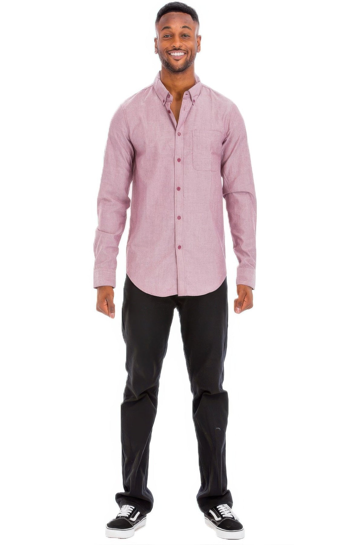 Man wearing a pink button-up shirt and black pants on a white background