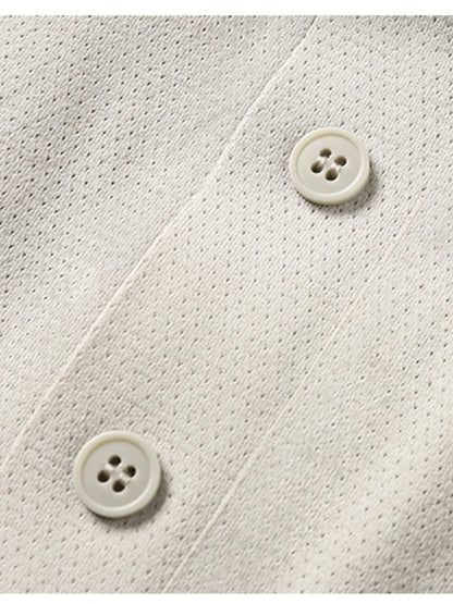 Close-up of a textured white fabric with two buttons on a matching background