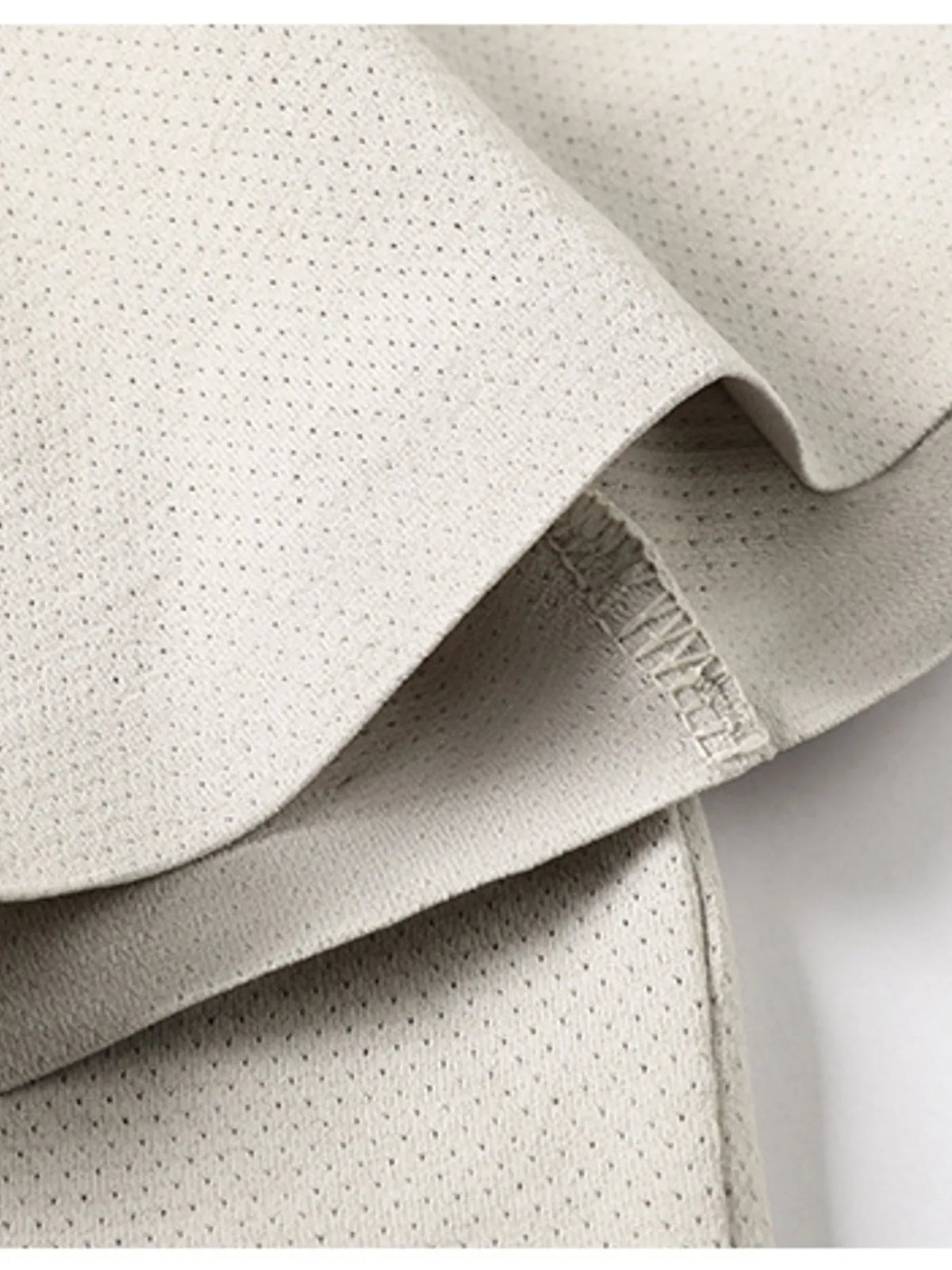 Close-up of textured beige fabric with a brand label.