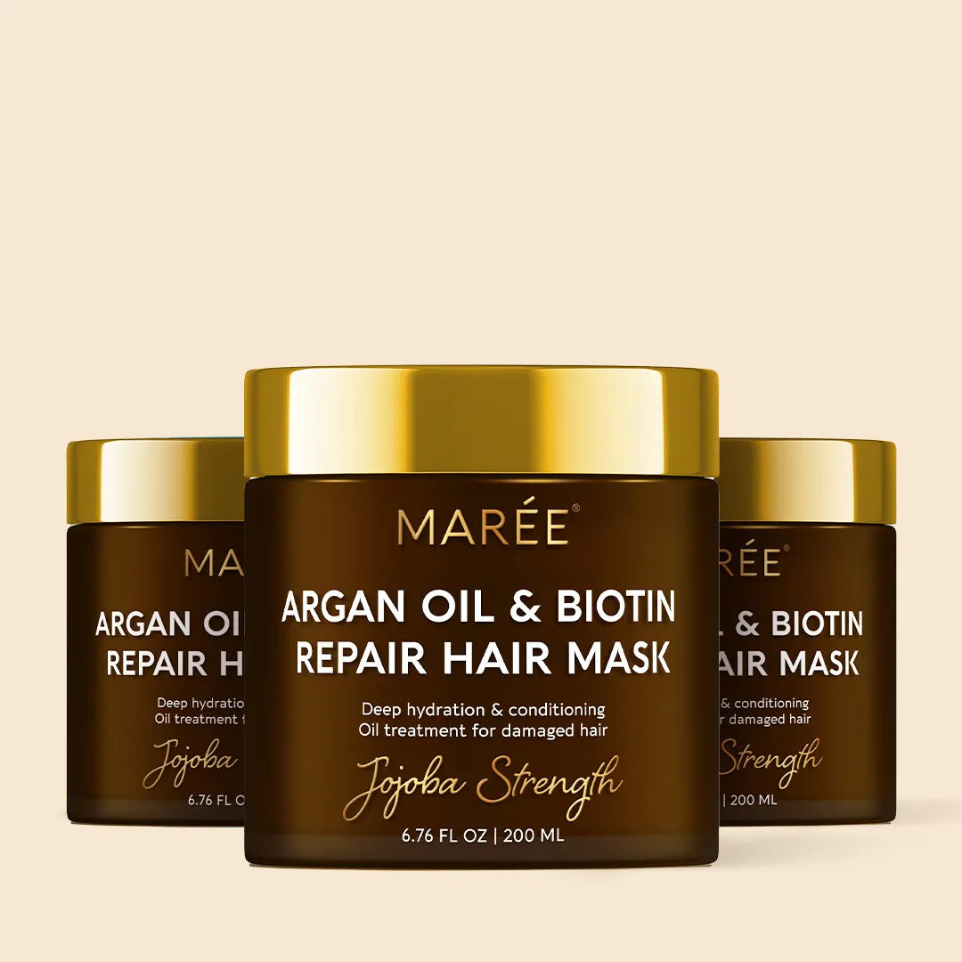 Three jars of Mareé Argan Oil & Biotin Repair Hair Mask on a beige background