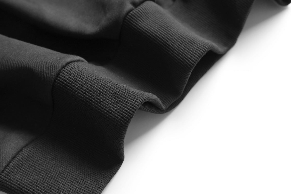Close-up of a black sweater sleeve on a white background