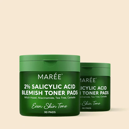 Two green containers of Marée 2% Salicylic Acid Blemish Toner Pads on a beige background