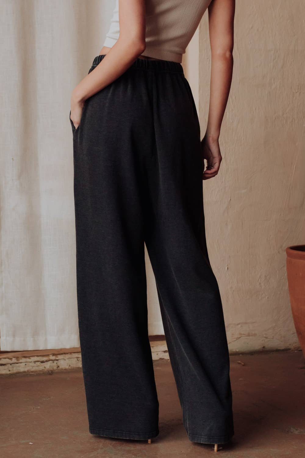 Person wearing black wide-leg pants with a neutral background