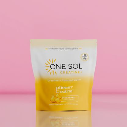 A stand-up pouch of One Sol Creatine+ dietary supplement in Pineapple flavor, featuring a white-to-yellow gradient design with a sun graphic and the Purest Creatine logo, set against a solid pink background.