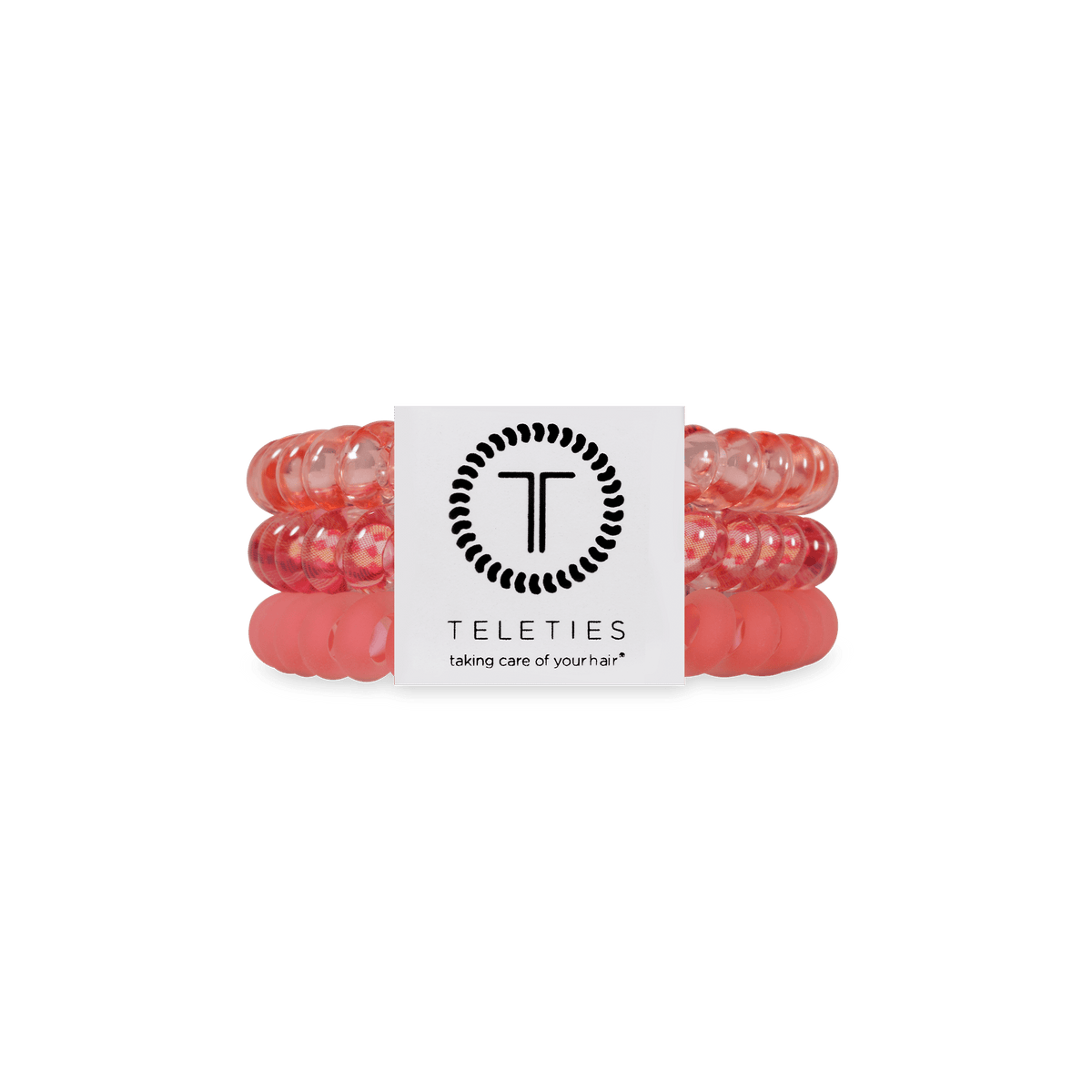 Three translucent coral-pink silicone hair ties stacked together with a white paper band featuring the black Teleties logo and the text 'taking care of your hair*'.