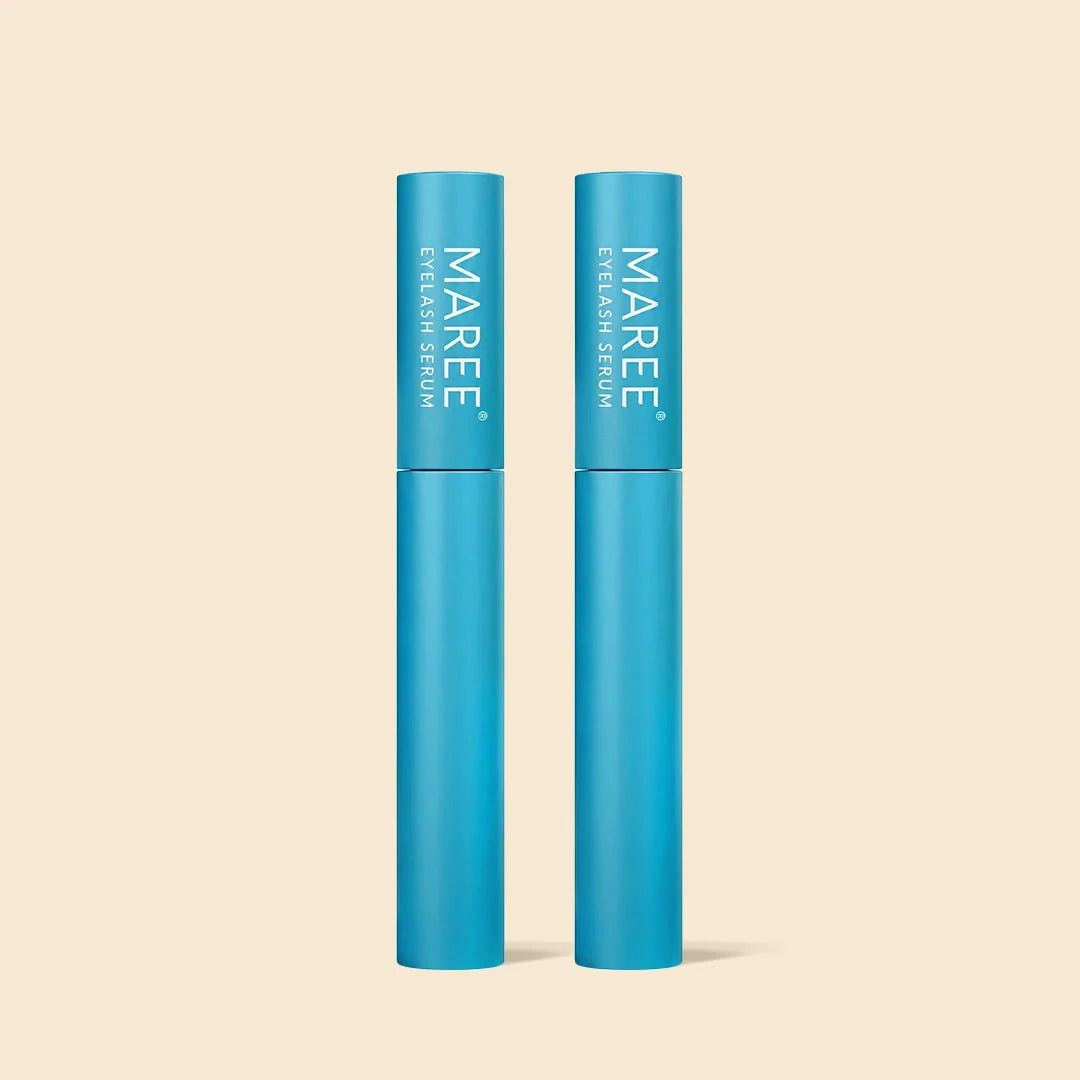 Two blue cylindrical tubes of MAREE Eyeshadow Serum standing upright on a light beige background.