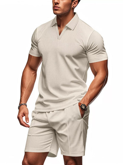 Man wearing a beige checkered polo shirt and shorts on a white background