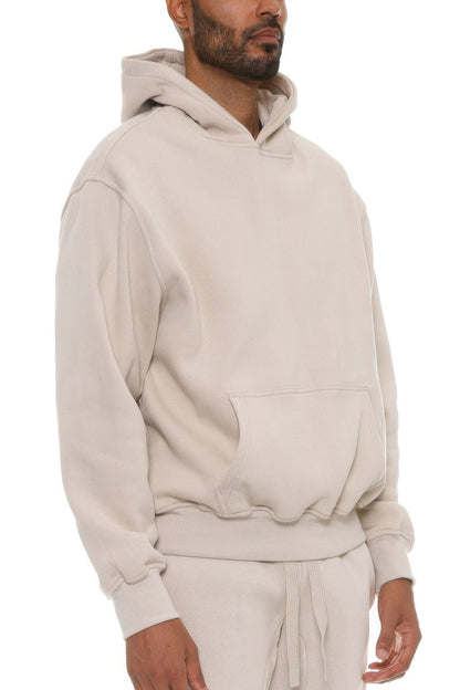 Man wearing a beige hoodie and pants on a white background
