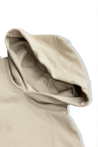 Close-up of a beige hoodie with a white background