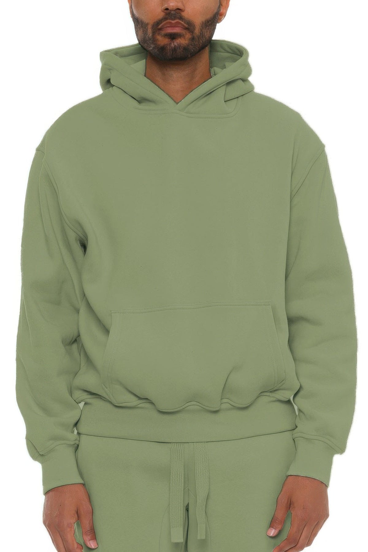Person wearing a green hoodie and pants on a white background