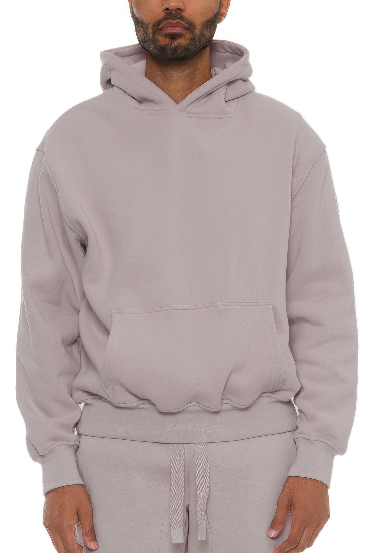 Man wearing a light gray hoodie and pants on a white background