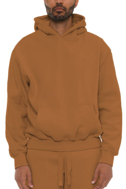 Man wearing a brown hoodie and pants on a white background