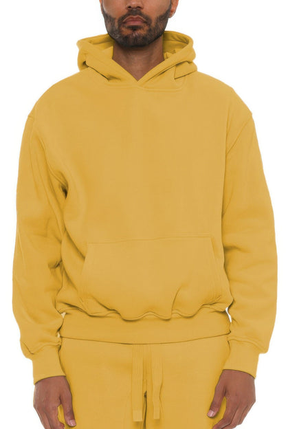 Person wearing a yellow hoodie and pants on a white background