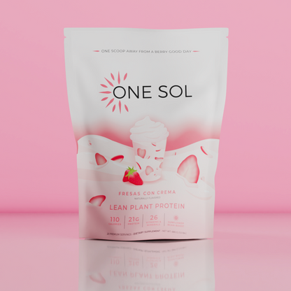 A stand-up pouch of One Sol Fresas Con Crema Lean Plant Protein dietary supplement, featuring a white and pink design with a strawberry graphic, set against a solid pink background with a soft reflection below.