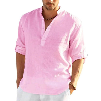 Man wearing a light pink shirt with rolled-up sleeves on a white background