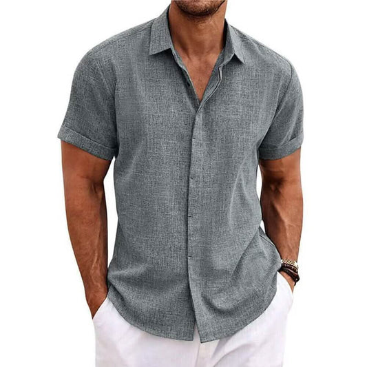 Man wearing a gray short-sleeve button-up shirt and white pants on a white background