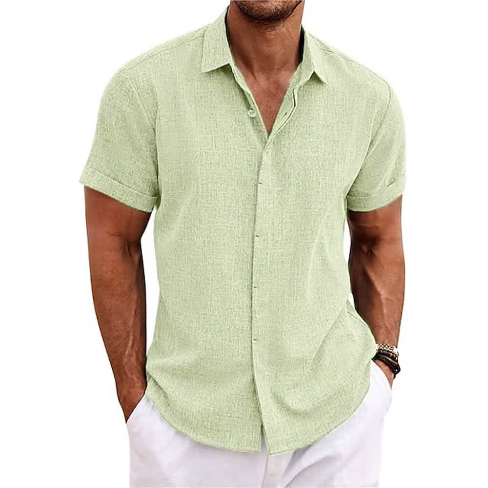 Man wearing a light green short-sleeve shirt and white pants on a white background