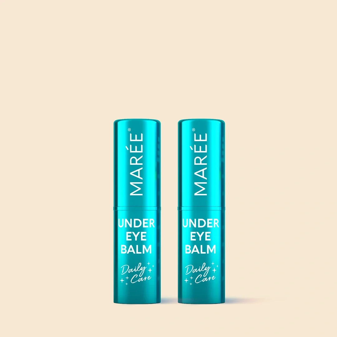Two teal blue MARÉE Under Eye Balm tubes standing side by side on a solid pale beige background.