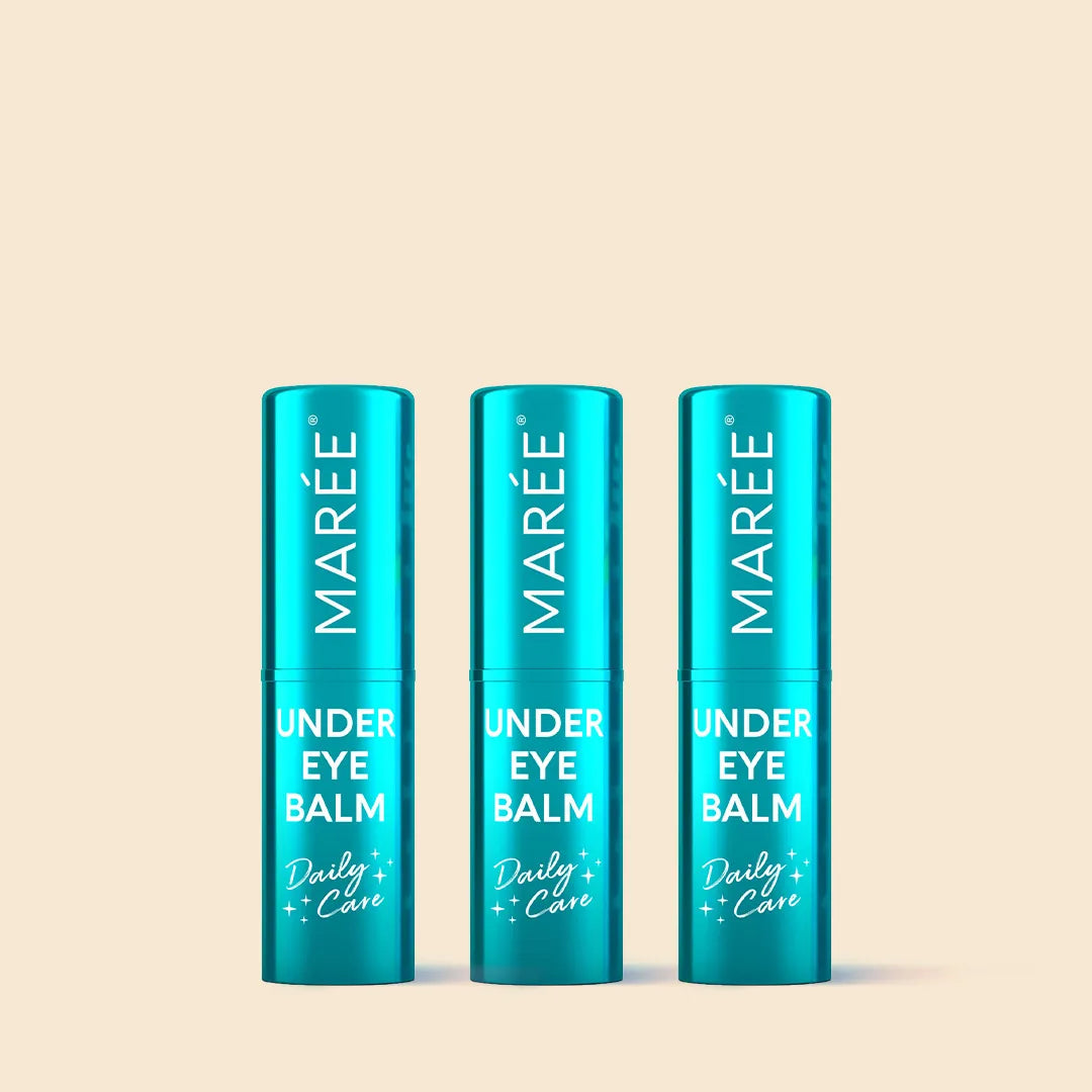 Three blue tubes of Marée Under Eye Balm on a beige background