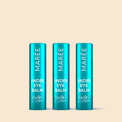 Three blue tubes of Marée Under Eye Balm on a beige background